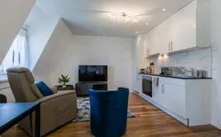 Ferienwohnung am Bodensee, Bild 1: Wohnzimmer mit Relexsessel, Fernseher, Küche.